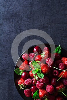 Fresh red ripe berries on black plate