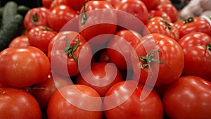 Fresh red ripe juicy tomatoes with stalks on the counter of a farm shop.