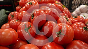 Fresh red ripe juicy tomatoes with stems on the counter of a farm shop.