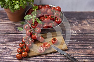 Manche tomaten auf der ranke auf der hölzern Platte die Küche ein messer 