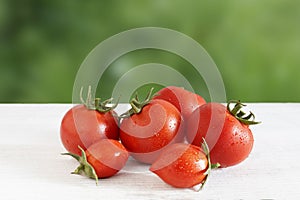 Fresh red ripe tomatoes on a wooden table against the backdrop of nature. organic, ecological vegetables tomatoes on a wooden