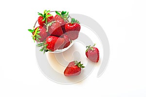 Fresh red strawberries in transparent bowl isolated on white background