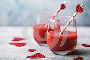 Fresh red strawberry margarita  or daiquiri cocktail with hearts over gray background, valentine day concepts