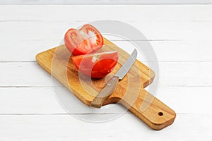 Fresh red tomato cut into two halves and the knife