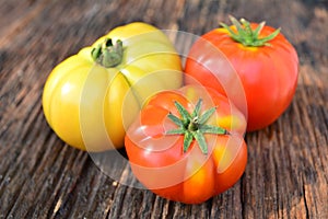 Fresh red tomato on old brown wood table at the morning