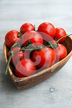 Fresh red tomatoes in wooden plate