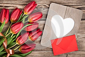 Fresh red tulips, blank frame and envelope