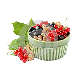 Fresh red, white and black currants in bowl with green leaf isolated on white