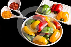 Fresh red,yellow and green capsicum slices also called bell pepper isolated on a black background.