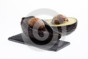 Fresh and ripe avocado next to rotting avocado cut in half with seed visible isolated on white