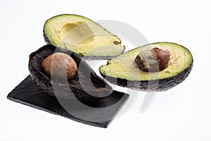 Fresh and ripe avocado next to rotting avocado cut in half with seed visible isolated on white