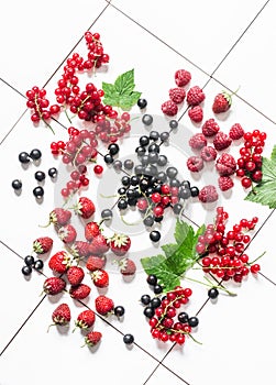 Fresh ripe berries - strawberry, red and black currant, raspberry on a light background, top view