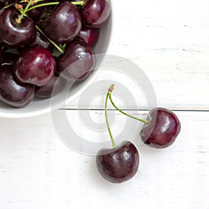 Fresh ripe black cherries in a white bowl