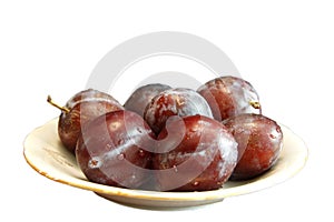 Fresh Ripe Black Plums In A White Plate Isolated On White Background