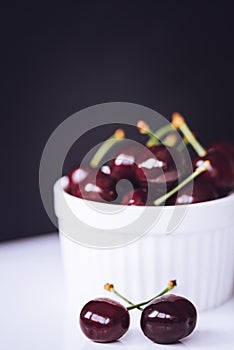 Fresh ripe cherries in ceramic bowl. Isolated on white background, close up. Healthy food concept.