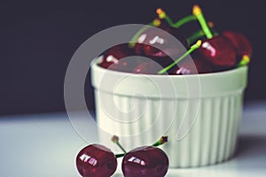 Fresh ripe cherries in ceramic bowl. Isolated on white background, close up. Healthy food concept.