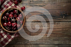 Fresh ripe cherries and towel on wooden table, flat lay, empty space