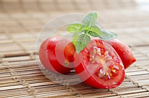 Fresh ripe cherry tomatoes and sweet basil on rustic wooden surface
