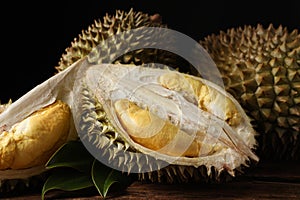 Fresh ripe durian fruits on wooden table, closeup