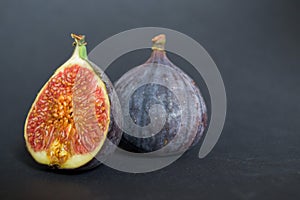 Fresh ripe figs on dark table. Healthy mediterranean fig fruit. Fresh figs on black background.