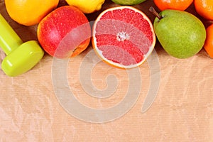 Fresh ripe fruits and dumbbells for fitness, healthy lifestyles