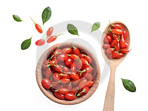 Fresh ripe goji berries, bowl and spoon on background, top view
