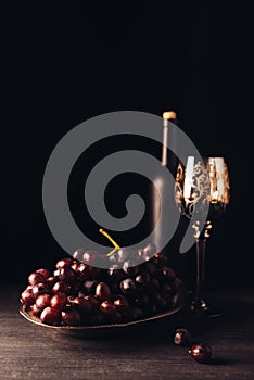 fresh ripe grapes glass and bottle of wine on wooden table
