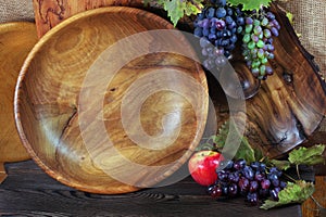 Fresh ripe grapes. Handmade wooden utensils on the kitchen table. Wooden plates, bowls and dishes on the table.