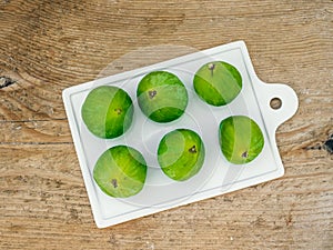 Fresh ripe green figs on a caramic cutting board
