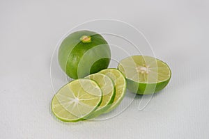 Fresh ripe green limes with sliced on white canvas background