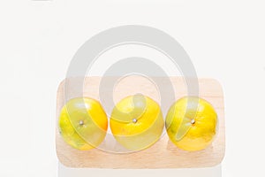Fresh ripe green and orange tangerine citrus, mandarin oranges, fruit on wood tray on white table background. Seasonal