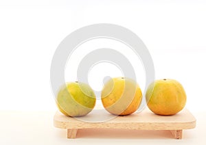 Fresh ripe green and orange tangerine citrus, mandarin oranges, fruit on wood tray on white table background. Seasonal