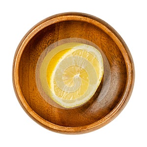 Fresh and ripe half lemon, yellow citrus fruit in wooden bowl