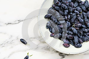 Fresh ripe honeysuckle berries in a ceramic bowl