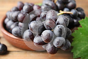 Fresh ripe juicy grapes in bowl on table