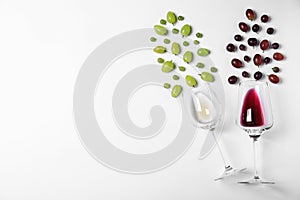 Fresh ripe juicy grapes and glasses of wine on white background