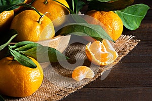 Fresh ripe juicy yellow mandarin  clementine, tangerine  on rustic vintage table with leaf