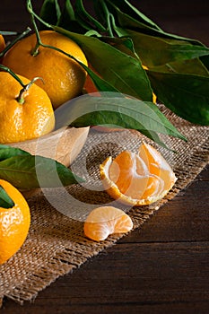 Fresh ripe juicy yellow mandarin  clementine, tangerine  on rustic vintage table with leaf