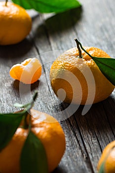 Fresh ripe juicy yellow mandarin  clementine, tangerine  on rustic vintage table with leaf