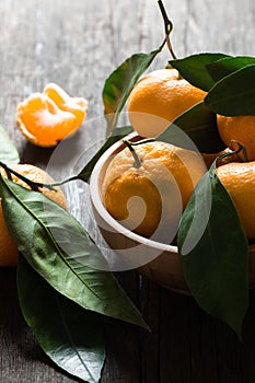 Fresh ripe juicy yellow mandarin  clementine, tangerine  on rustic vintage table with leaf