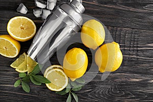 Fresh ripe lemons with shaker on wooden table