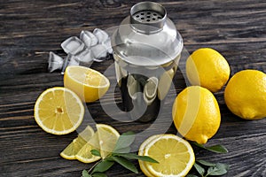 Fresh ripe lemons with shaker on wooden table