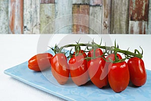 Fresh ripe mini marzano tomatoes on blue board