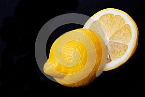 Fresh Ripe Organic Lemon cut in half isolated on black. Citrus Limon. Rutaceae family.