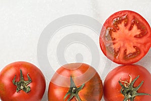 Fresh Ripe Organic Red Tomatoes Whole Halved on White Marble Stone. Italian Spanish Greek Mediterranean Cuisine