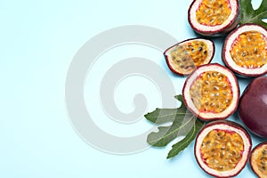 Fresh ripe passion fruits maracuyas with green leaves on light background, flat lay. Space for text