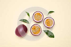 Fresh ripe passion fruits maracuyas with leaves on beige background