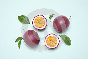 Fresh ripe passion fruits maracuyas with leaves on light background