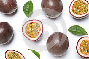 Fresh ripe passion fruits maracuyas with leaves on white background, flat lay