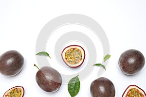 Fresh ripe passion fruits maracuyas with leaves on white background, flat lay. Space for text